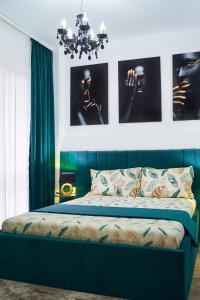 雅西New Apartments IuliusMall-Apartamente cu 2 camere的一间卧室配有一张带绿色窗帘和吊灯的床。
