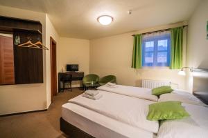 普拉哈季采克朗普拉查斯酒店的一间卧室设有两张床、一张桌子和一个窗口。