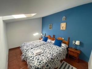 蒙特霍-德拉谢拉Alojamientos El Horno的蓝色卧室,配有蓝色墙壁的床