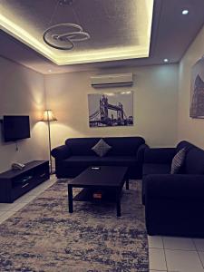 Abḩur al Janūbīyahايزي للوحدات المخدومة的带沙发、桌子和电视的客厅