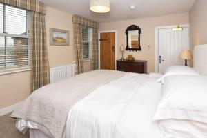 BiddulphThe Royal Oak的卧室配有一张白色大床和镜子