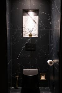 斯赫拉芬赞德Royal Suite的黑色浴室设有卫生间和窗户。
