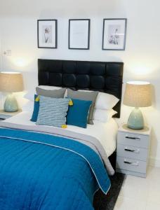 沃尔索尔Anson Studios Walsall M6, J10的一间卧室配有一张带两盏灯的蓝色和白色的床。