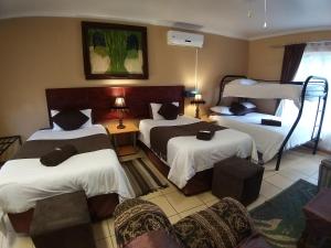 路易特里哈特The Ultimate Lodge的酒店客房,设有三张床和椅子