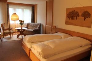 吕策尔弗吕奥伯多夫社区酒店的一间卧室配有两张床、一把椅子和一张桌子