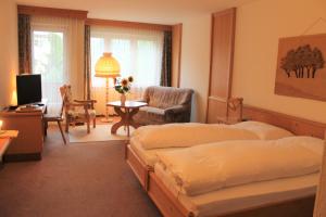 吕策尔弗吕奥伯多夫社区酒店的一间卧室配有两张床、一把椅子和一张书桌