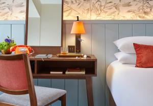 阿斯隆霍德森海湾酒店的一间卧室配有一张桌子、一张床和一盏灯