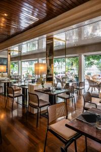 梅拉诺欧若拉酒店的餐厅设有桌椅和窗户。