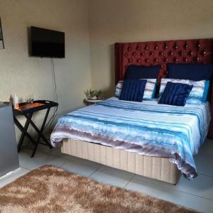索韦托Lapa la Bakgatlha的一间卧室配有一张大床和一张桌子及一台电视