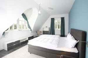 洛布Strandhaus Buskam im Mönchgut auf Rügen的一间卧室设有一张大床和一个窗户。