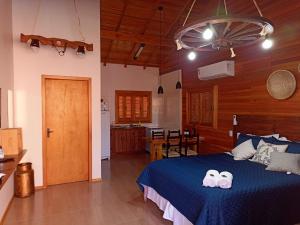 圣若阿金Aconchego da Serra Geminados的一间带蓝色床的卧室和一间厨房