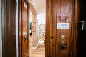 斯培西亚Design Suite Cinque Terre La Spezia的木门上带有标志的走廊