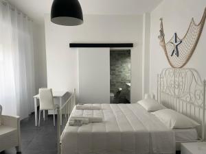 圣萨尔沃B&B FRONTEMARE San Salvo Marina CH的白色卧室配有床和桌子