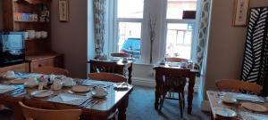 布里德灵顿Bagshaw Bed & Breakfast的一间带桌椅的用餐室和窗户。