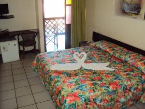 波托德索比萨维皮河口生态酒店的两个天鹅被画在旅馆房间的床上