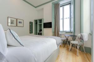 卡斯卡伊斯Westlight Cascais Chalet - Adults Only的卧室配有白色的床、桌子和窗户。