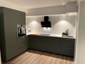 莱克内斯Lofoten - New apartment, close to airport.的厨房配有黑色橱柜和水槽
