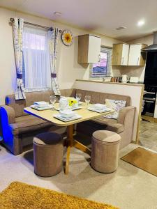 塔特舍尔The Sunflower Luxury caravan at Tattersall lakes的厨房以及带桌椅的起居室。