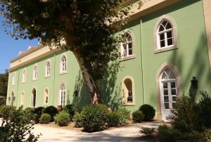 辛特拉辛特拉金塔圣塞巴斯蒂昂之家旅馆的绿色建筑,有白色的窗户和树