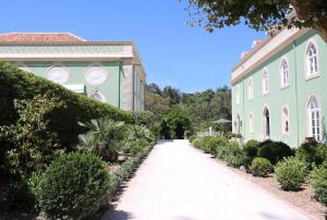 辛特拉辛特拉金塔圣塞巴斯蒂昂之家旅馆的通往灌木丛和树木的建筑的步行道