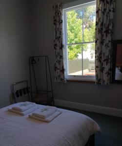 纳皮尔Milton Cottage的一间卧室配有床,窗户配有毛巾