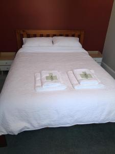 纳皮尔Milton Cottage的一张带白色床单和毛巾的床