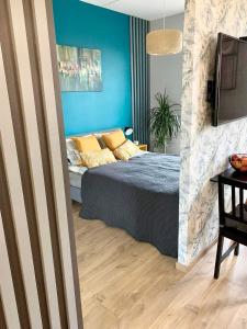 别尔斯克-比亚拉Apartament Urodzajna的一间卧室设有一张床和蓝色的墙壁