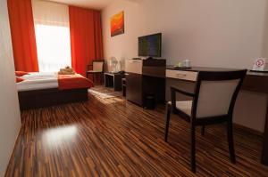 科希策贝丽尔酒店的酒店客房设有一张桌子、一张床和一间卧室。