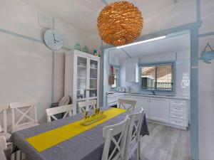Long JettyPacific Family Retreat的厨房以及带桌子和时钟的用餐室。