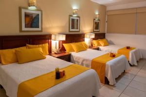 阿瓜斯卡连特斯Hotel San Antonio的酒店客房,设有三张带黄床单的床
