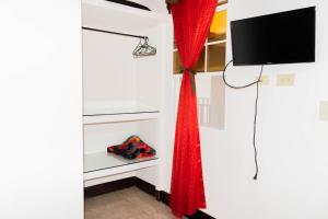 SomotoHostal San José的配有电视和红色窗帘的房间