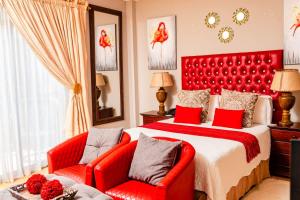 哈特比斯普特Re-Union Vacations的一间卧室配有红色的床和两张红色椅子