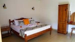 拉迪格岛Villa Antonia的一间卧室配有一张床和一个木制橱柜