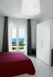 特拉帕尼布雷莎迪格乐卡尔酒店的一间设有红色床的卧室,享有海景