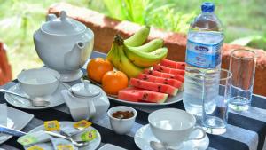 丹不拉Sayare Inn的一张桌子,上面放着一盘水果和一瓶水