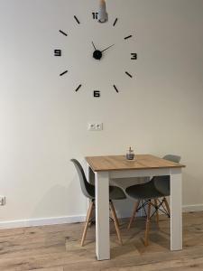 什切青Apartment Insat II的桌子、椅子和墙上的时钟