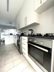 科尔切斯特10 on Aquavista Addo River View Cottage的厨房配有白色橱柜和炉灶烤箱。