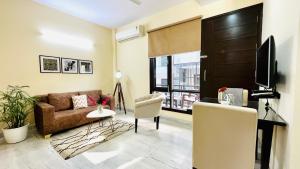 古尔冈BluO 1BHK - DLF Golf Course Road , Balcony, Lift的带沙发和电视的客厅