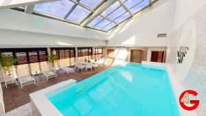 戛纳THE POOL HOUSE Cannes的一座带桌椅的别墅内的游泳池