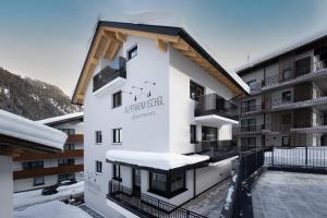 伊施格尔Alpenheim Apartment Ischgl的屋顶上积雪的建筑