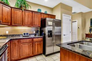 霍利斯特Villa Vista的厨房配有木制橱柜和不锈钢冰箱。