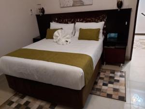 卡萨内Top Stay Inn的一间卧室配有一张大床,床上放着鲜花