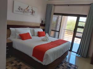 卡萨内Top Stay Inn的一间卧室配有一张带红色和白色枕头的大床
