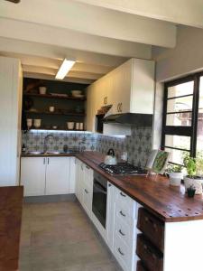 Sunridge ParkLoft on Honey的厨房配有白色橱柜和木制台面