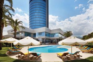 伊兹密尔伊兹密尔奥迪莱克温德姆大酒店的一个带游泳池和椅子的度假胜地和一座建筑