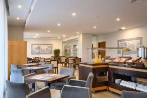 波尔图TRYP by Wyndham Porto Centro Hotel的一间带桌椅和壁炉的餐厅