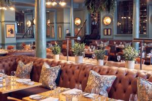 亨利昂泰晤士亨利杜文酒店的餐厅设有桌椅和棕色沙发