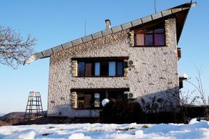 Chervena Lokva达斯卡洛夫旅馆的雪中带梯子的石头房子