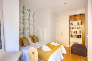 马德里Heima Retiro Park-Ibiza的一间小卧室,配有床和书架