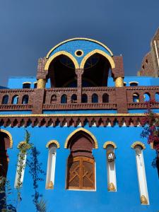 卢克索Golden Palace Garden的蓝色的建筑,设有棕色的门和窗户